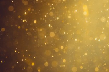Siyah arkaplanda koyu soyut altın bokeh parıltısı