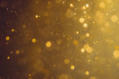 Siyah arkaplanda koyu soyut altın bokeh parıltısı