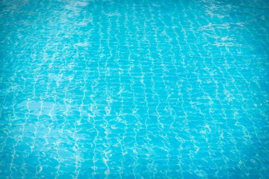 Mavi yüzme havuzunun arka planındaki sudan yansımalar.