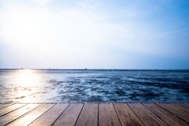 Ahşap zemin, günbatımı arka planında su düştüğünde denize doğru uzanıyor.