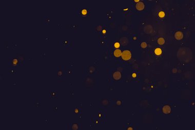 Siyah arkaplanda koyu soyut altın bokeh parıltısı