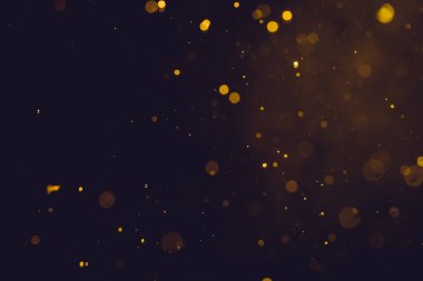 Siyah arkaplanda koyu soyut altın bokeh parıltısı