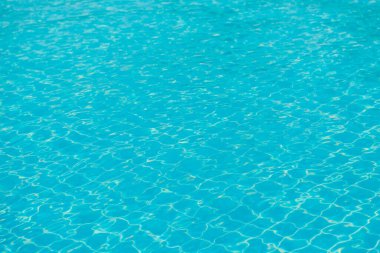 Mavi yüzme havuzunun arka planındaki sudan yansımalar.