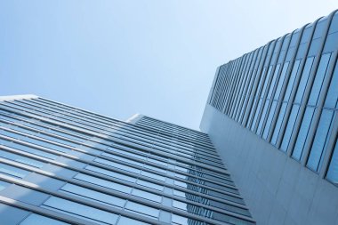 Cam, gökyüzü arka planına sahip modern iş merkezi.