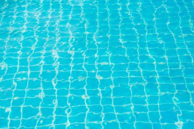 Mavi yüzme havuzunun arka planındaki sudan yansımalar.