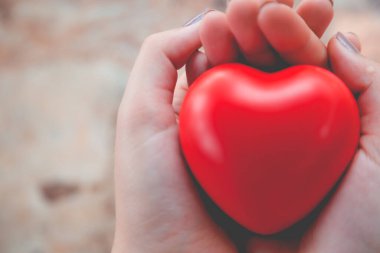 Kadın arka plan için kırmızı kalp kullanım tutun