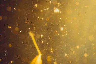 Siyah arkaplanda koyu soyut altın bokeh parıltısı