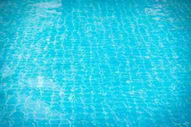 Mavi yüzme havuzunun arka planındaki sudan yansımalar.