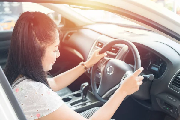 Güzel bir Asyalı kadın mutlu bir araba sürmeyi sever.