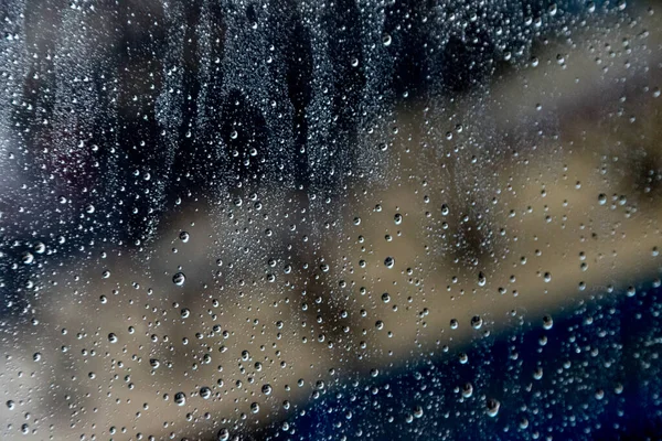 背景がぼやけてフロントガラスに雨が降ります — ストック写真