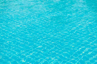 Mavi yüzme havuzunun arka planındaki sudan yansımalar.