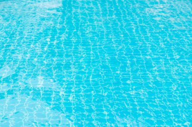 Mavi yüzme havuzunun arka planındaki sudan yansımalar.