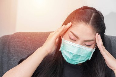 Asyalı kadın Covid hastalığından korunmak için tıbbi maske takıyor..