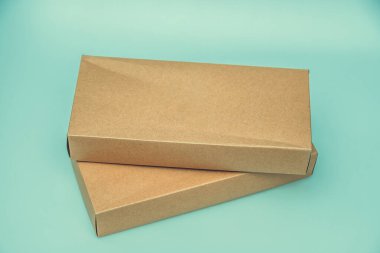 Yeşil arkaplanda boş karton kutu izole edildi