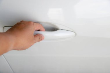 Şoför ya da sürücü eli beyaz araba kapısını açıyor. Yeni araba.