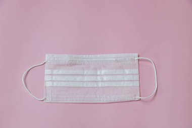 Face mask to help prevent infection from Covid-19 on pink background