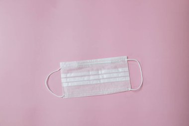 Face mask to help prevent infection from Covid-19 on pink background