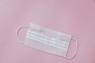Face mask to help prevent infection from Covid-19 on pink background
