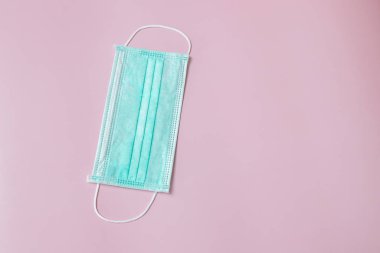 Face mask to help prevent infection from Covid-19 on pink background