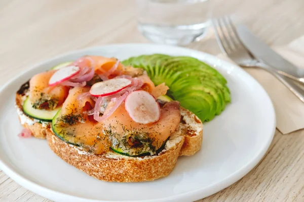 Salmon toast with avocado and vegs in the modern cafe — Stock Photo, Image