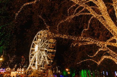 Noel pazarında ağaçlarda çelenk süslemesi