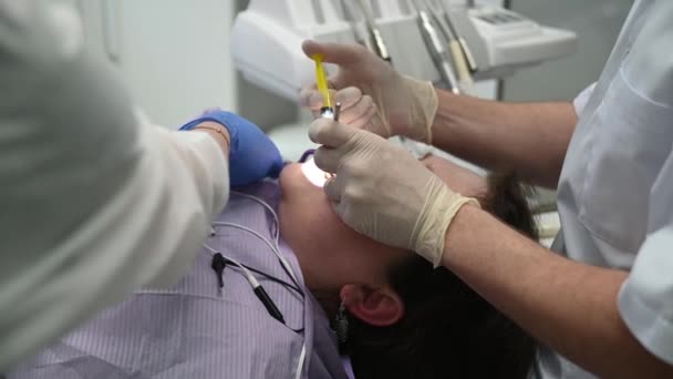 Стоматолог Промывает Канал Зуба Пациенту Помощью Микроскопа — стоковое видео