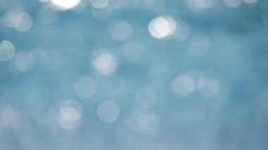 Su yüzeyindeki ışık yansıması, arka plandaki yumuşak ışığı yok etti. Bokeh güneşi su yüzeyine yansıyor. Güneş ışınları su akıntısında titreşiyor..