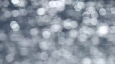 Su yüzeyindeki ışık yansıması, arka plandaki yumuşak ışığı yok etti. Bokeh güneşi su yüzeyine yansıyor. Güneş ışınları su akıntısında titreşiyor..