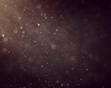 Defocused soft light and bokeh glitter lights background. Golden shimmering particles abstract bokeh glitter background. Abstract dust bokeh background.