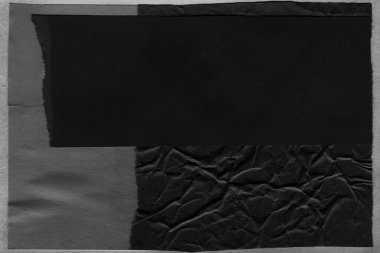 black and white dark Torn paper collage close-up. Texture made from various paper and cardboard parts. Damaged old paper background. Old grunge ripped torn vintage collage backdrop and background.
