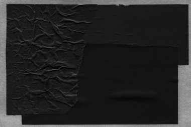 black and white dark Torn paper collage close-up. Texture made from various paper and cardboard parts. Damaged old paper background. Old grunge ripped torn vintage collage backdrop and background.