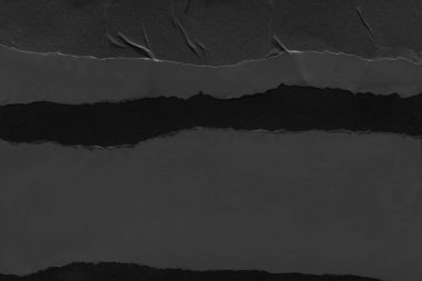 black and white dark Torn paper collage close-up. Texture made from various paper and cardboard parts. Damaged old paper background. Old grunge ripped torn vintage collage backdrop and background.