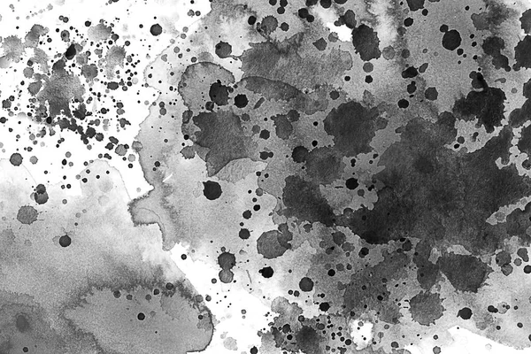 Black and white water color splash over a white canvas or textured paper. Ink drops. Paint splash, grunge liquid drop splashes, abstract artistic ink splatter. Black ink splashes on a white background