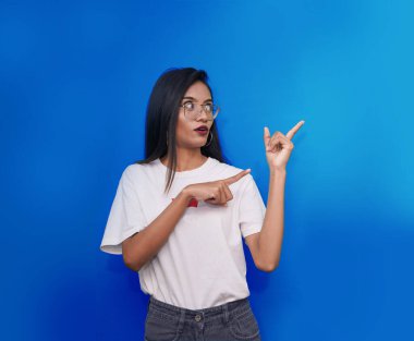 Reklam konsepti. Genç Hintli kız parmak uçlarını fotokopi aletiyle gösteriyor. Bilgi için. Genç Asyalı kadın beyaz tişört giyiyor..