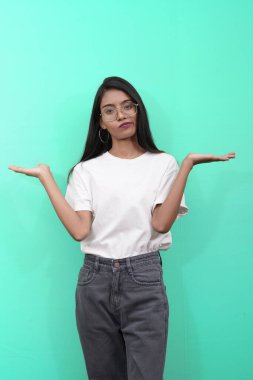 Kafası karışmış genç Hintli Asyalının iki elini açması hoşnutsuz ve tatminsiz görünüyor. Metin yazmak için kopyalama alanı olan reklam kavramları.