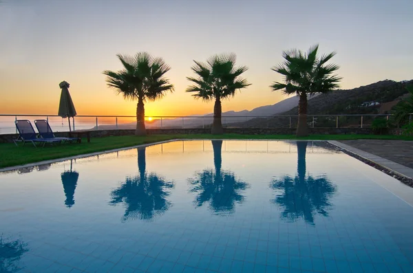 Palme e piscina in un'alba egea — Foto Stock