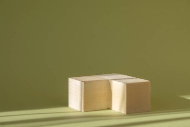 Tahta karelerden yapılmış doğaçlama 3D podyum yeşil arka planda güneş ışığı ışınlarıyla. Kozmetik ürünlerinin sunumu kavramı.