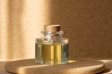 Yuvarlak ahşap tezgahta güneş ışığında kozmetik yağlı kare şişe. Tek renkli bej arkaplan ve güneş parlaması. 3d podyum kavramı.