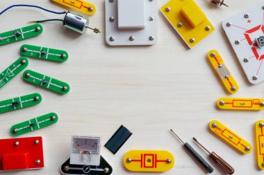 Beyaz ahşap arka planda çeşitli elektronik parçaların çerçevesi. Reklam için maket, poster. Yaklaş, düz yat. Robotlarda eğlence bilimi kavramı, çocuklar için elektronik..