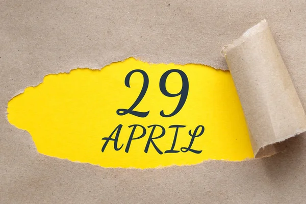 四月二十九日每个月的第29天 日历日期 撕开边缘的纸孔 黄色的背景通过破洞是看得见的 年月日概念 — 图库照片