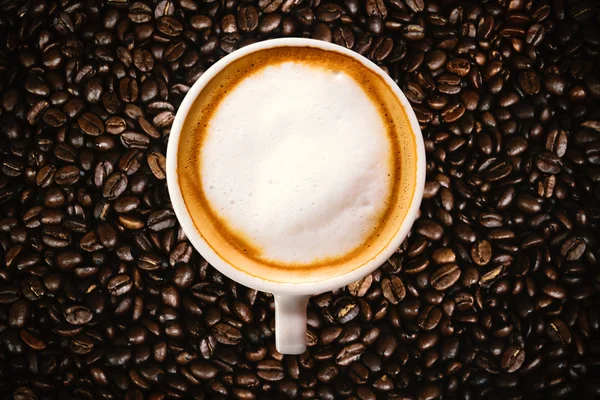 Tazza di caffè caldo su scintillante di chicchi di caffè — Foto Stock