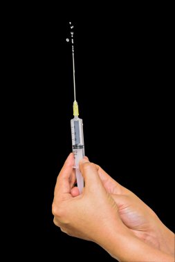 Doktor veya hemşire olarak eldiven el ile şırınga siyah arka plan üzerine