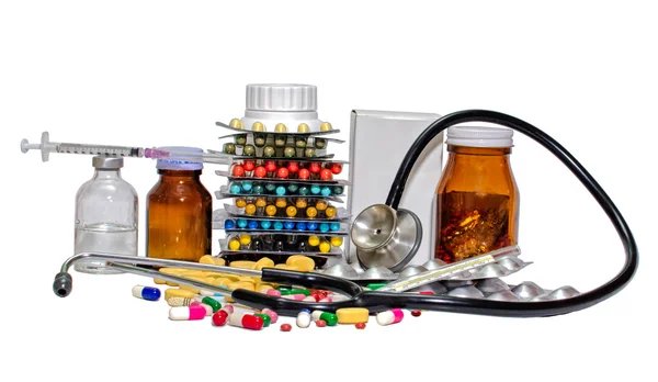 Verschillende kleur pillen capsule, syring, stethoscoop op een witte achtergrond — Stockfoto
