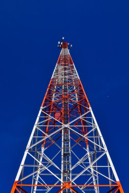 Mavi gökyüzüne karşı antenli iletişim kulesi