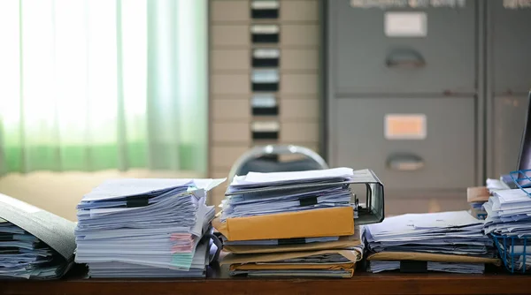 Blurred Busy Cluttered desk workplace, full of documents A mess desk with many working stuff.