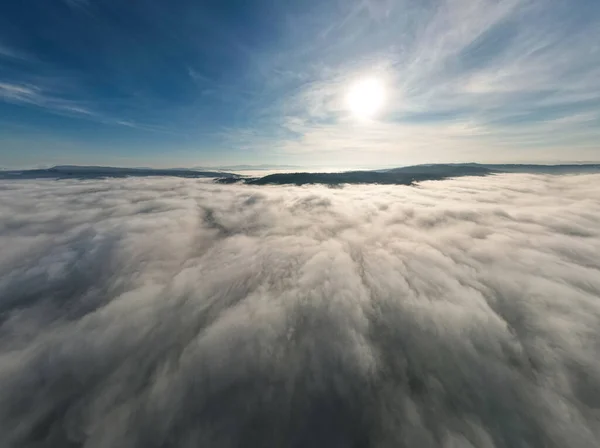 飛行機の窓から山の上の雲と空 朝の自然の背景のための空中ビュー — ストック写真
