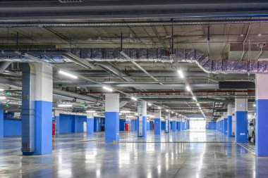 Ticari bir binanın yeraltı otoparkında. Havalandırma ve havalandırma sisteminin havalandırma kanalları, yangın söndürme sisteminin boruları, tavanın altındaki elektrik kabloları..