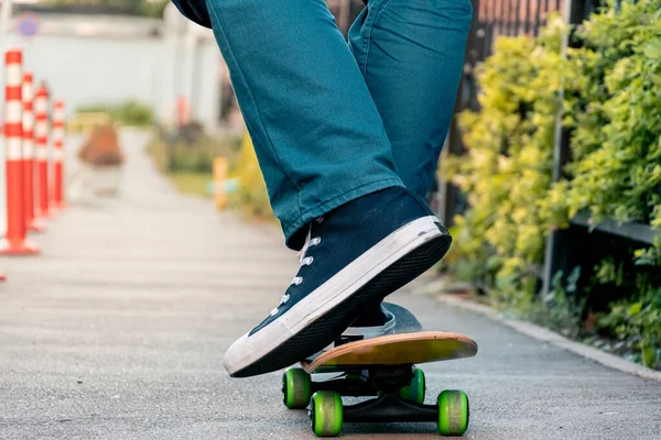 Close Van Mannenbenen Jeans Sportschoenen Een Skateboard Een Stadsstraat Bij — Stockfoto