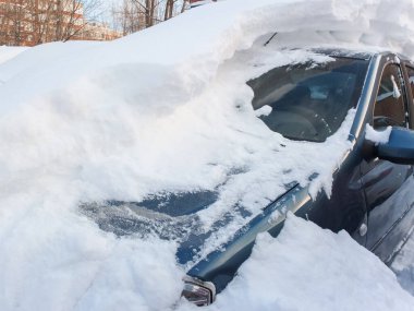 Kar temizleyen araba sürücülerinin kış sorunları. Kar yağdıktan sonra şehir caddesinde karla kaplı arabalar..