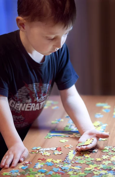 Pojke lösa ett pussel - utbildning Royaltyfria Stockbilder